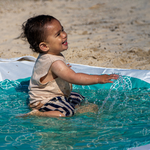Toddler playing beach puddle