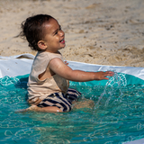 Toddler playing beach puddle